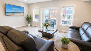 Een woonkamer met leren banken, een salontafel en een televisie waarop 'WILDWOOD New Jersey' staat.