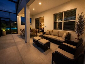 An outdoor patio with a dining area, a sofa set, and a potted plant. - Grand Orion Twin Villas side by side 24BR 22BA Luxury Resort Near Disney (kissimmee)