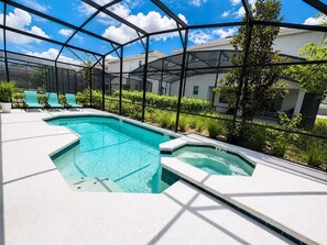 A pool area with a glass enclosure, lounge chairs, and a view of a building. - Grand Orion Twin Villas side by side 24BR 22BA Luxury Resort Near Disney (kissimmee)