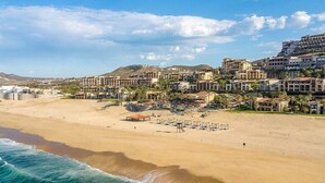 Ein Hotel an der Küste mit direktem Strandzugang, mehreren Gebäuden und einem Sandstrand.