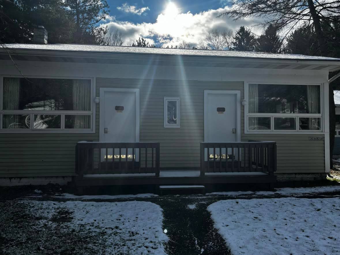 A single-story building with a front porch, two doors, and windows.