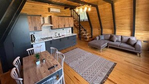 Habitación estilo loft con cocina, comedor y sofá.