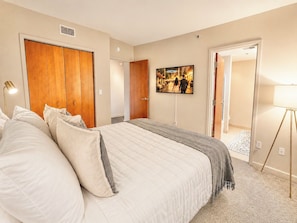A bedroom with a large bed, a wardrobe, a television on the wall, and a lamp. - Downtown Walk To Restaurants Ferry By Cedar Point (Sandusky)