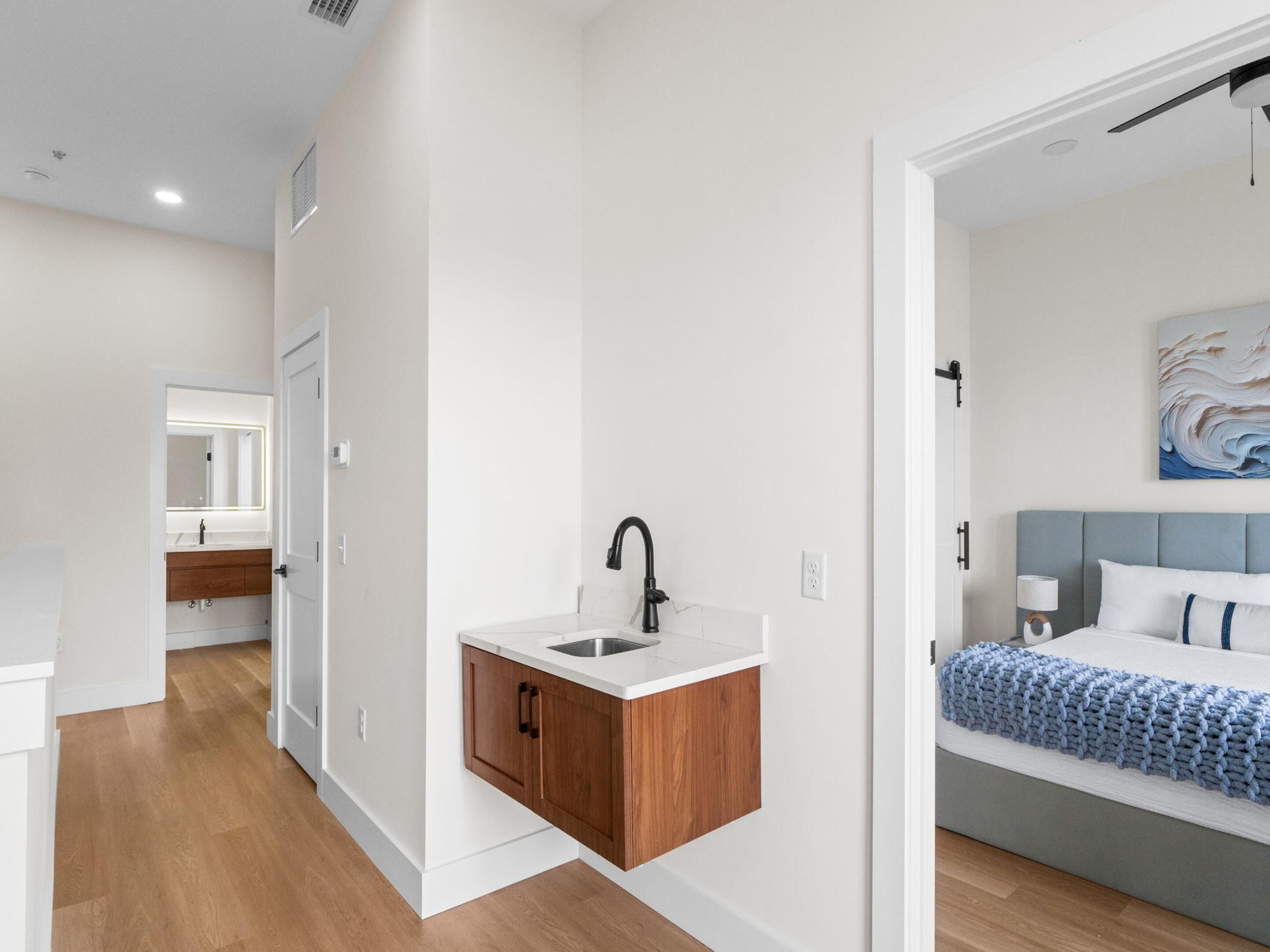 A modern bedroom with a bed, bedside table, and a nightstand.