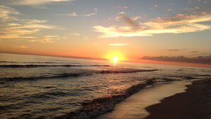 A sunset over the ocean with waves approaching the shore. - Paradise Point 3 BR home overlooking the bay in gorgeous Saint George Island (Saint George Island)