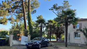 A residential property with a parked car, a paved driveway, and surrounding trees. - Family villa with a stunning view of the countryside, close to the beaches and marshes (Breuillet)