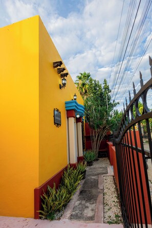 Un edificio amarillo con un letrero que dice 'CASA CENTRO' y una entrada protegida por una reja.