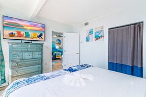 A bedroom with a bed, a dresser, a television, and a door leading to another room. - Penthouse on 14th Ave Pier! 1BR Yachtsman 1101 (Myrtle Beach)
