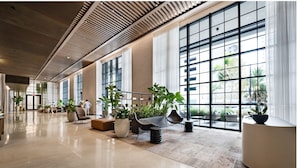 A spacious lobby with large windows, modern furniture, and potted plants. - Luxury Miami 1BR - 25th Fl - Pool & Gym (Miami)