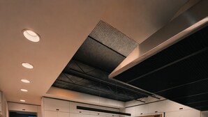 Eine moderne Küche mit weißen Schränken, einer Marmorinsel und einer schwarzen Decke.