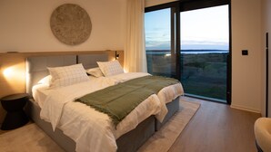 Ein Schlafzimmer mit großem Bett, Blick ins Freie und modernem Design.