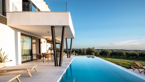 Ein moderner Poolbereich im Freien mit freiem Blick auf die umliegende Landschaft.