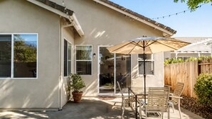 A house with a patio, a table and chairs, a potted plant, and a wooden fence. - Grace Vista Spacious Near Downtown, Bars, UC Davis (West Sacramento)