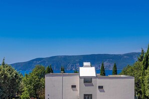 Ein modernes Gebäude mit flachem Dach, einem kleinen Fenster und einem Schornstein.