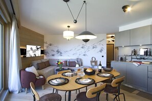 A modern interior with a dining area, kitchen, and living space. - 10m from ski slopes, fitness, swimming pool, sauna, hammam, tv, ski locker, 52m², Alpe d'Huez (Huez)