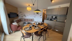 A modern living space with a dining area, kitchen, and a sofa set. - 10m from ski slopes, fitness, swimming pool, sauna, hammam, tv, ski locker, 52m², Alpe d'Huez (Huez)