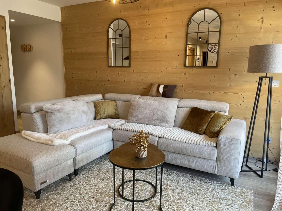 A modern living room with a sectional sofa, a round coffee table, and a floor lamp.