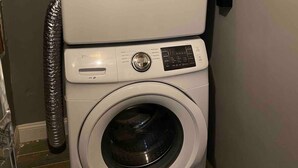 Una lavadora y secadora apiladas en un cuarto de lavado.