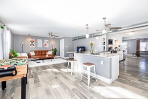 A modern kitchen with a central island, bar stools, and a foosball table. - Mins To Zoo Anheuser Brewery Childrens Hospital (St. Louis)