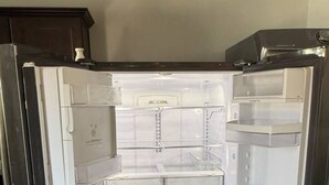 Un frigorífic d'acer inoxidable amb diversos compartiments, incloent un congelador, l'apartament principal i un dispensador d'aigua.