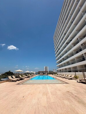 A rooftop pool with lounge chairs and umbrellas, surrounded by a high-rise building. - Ocean View Suite in Cartagena 🌊 Pool • Beach • Airport in Crespo (Cartagena de Indias)