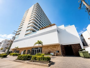 A modern hotel with a prominent corner building, a landscaped entrance, and a clear sky. - Ocean View Suite in Cartagena 🌊 Pool • Beach • Airport in Crespo (Cartagena de Indias)