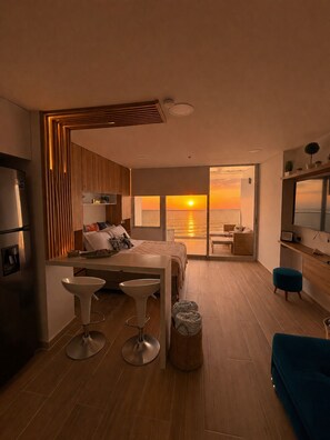 Une chambre moderne avec un lit, un bureau et une vue sur le coucher du soleil.