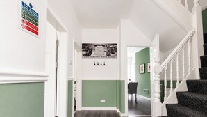 Ein Flur mit grüner Wand, einem Brandschutzschild und einem Motivationsplakat.