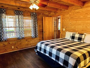 A wooden cabin room with a bed, curtains, and a ceiling fan. - The Roosevelt - Close to Mountainside pool! (Warm Springs)