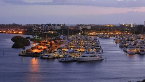 Un port de plaisance où de nombreux bateaux sont amarrés, entouré de bâtiments et bordé par une étendue d’eau.