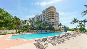 Un hôtel doté d’une piscine, de chaises longues et de palmiers.