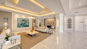 A modern living room with a sofa, coffee table, and artwork. - Luxury Rental in Bay Isles facing the Bay (Longboat Key)