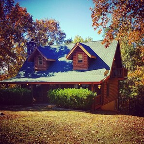 A two-story log cabin with a gabled roof and a small tower-like structure on the right. - Perfect cabin for large families (Warm Springs)
