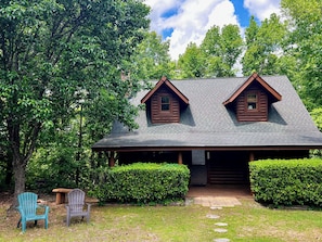 A cabin with a porch, two windows, and a covered entrance.