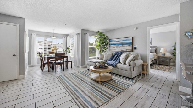 A spacious living room with a dining area, a sofa, and a coffee table. - Lakeside view retreat at Villas del Sol (Kissimmee)