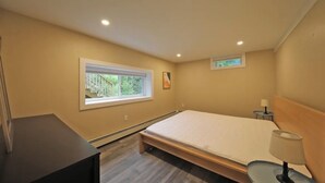 A bedroom with a bed, a small bedside table, a lamp, a window, and a picture on the wall. - Visit us 3 minutes from Tanglewood music hall and Kripalu Yoga Center (Lenox)