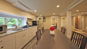 A spacious kitchen with a dining table, chairs, and a vase of flowers. - Visit us 3 minutes from Tanglewood music hall and Kripalu Yoga Center (Lenox)