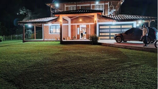 A modern two-story house with a garage, a covered porch, and a well-maintained lawn.