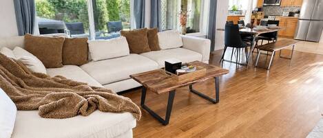 Una sala moderna con sofá, mesa de centro y comedor.