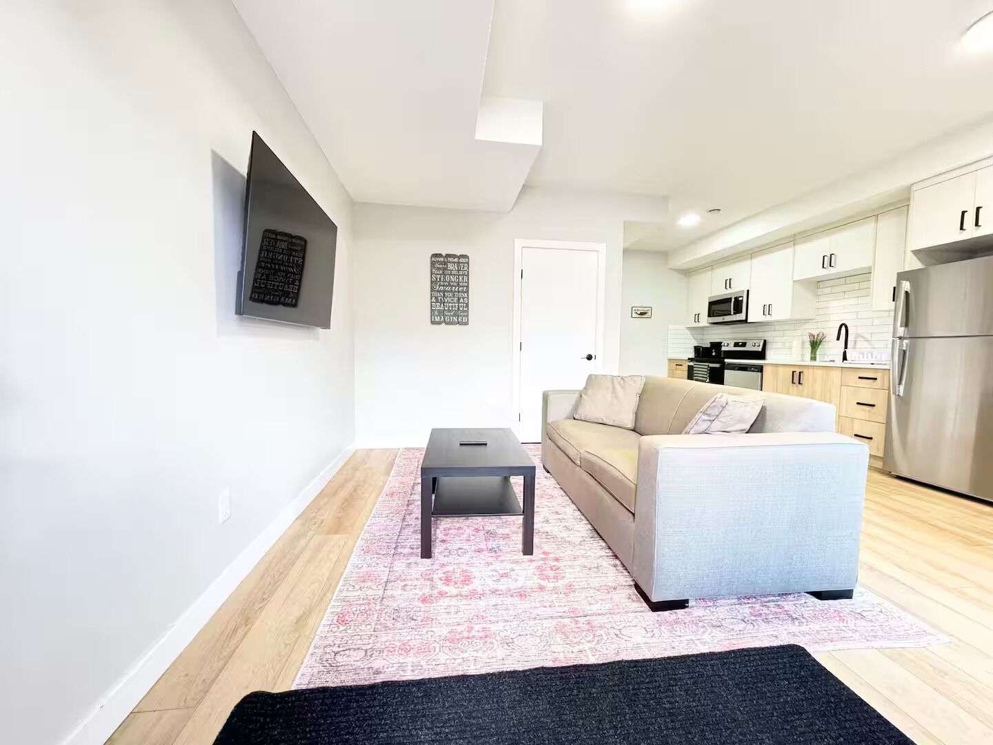 A modern living room with a sofa, a coffee table, and a rug.