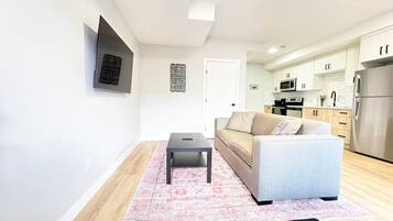 A modern living room with a sofa, a coffee table, and a rug.