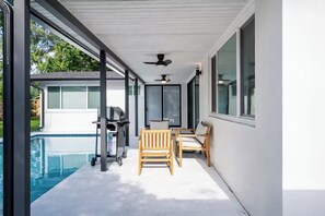 A covered outdoor area with a pool, a grill, and seating. - Luxury Pool Retreat • Near Hard Rock • Sleeps 10 (Fort Lauderdale)