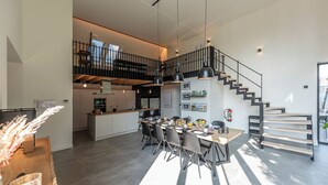 Eine geräumige Küche mit Essbereich, einer Treppe und Blick ins Freie.