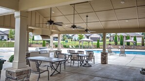 An outdoor patio with a grill, seating, ceiling fans, and a pool in the background. - Marvelous 4-bedroom house, 5 miles from the square in vibrant Athens (Athens)
