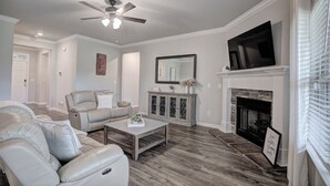 A living room with a fireplace, a television, and a ceiling fan. - Marvelous 4-bedroom house, 5 miles from the square in vibrant Athens (Athens)