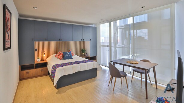 Ein modernes Schlafzimmer mit Bett, Schreibtisch und Stuhl.