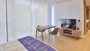 Ein Schlafzimmer mit einem Bett, einem Schreibtisch, einem Fernseher und einem Kleiderschrank.