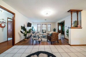 A spacious living room with a fireplace, a television, and a dining area with a table and chairs.