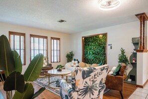 A living room with a sofa, a coffee table, and a decorative wall.