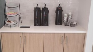 A kitchen counter with a coffee maker, a food processor, and a dish rack. - Battle Creek Hotel (Battle Creek)